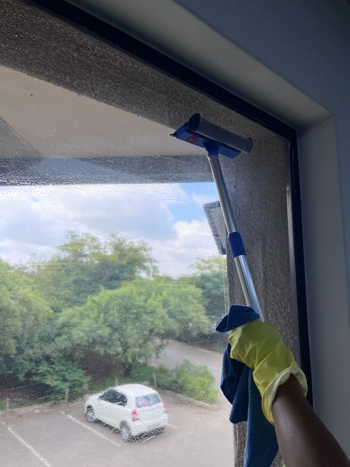 Worker using an extension pole with a squeegee